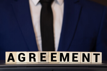 AGREEMENT word on wooden cubes on gray background