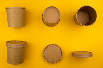 The concept of eco fast food. Soup container with a croup of eco-friendly material on a yellow background close-up with a copy space.