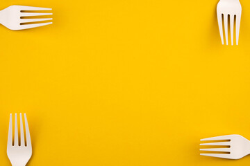 The concept of eco fast food. Forks of eco-friendly material on a yellow background close-up with a copy space