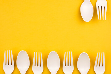 The concept of eco fast food. Forks and spoons of eco-friendly material on a yellow background close-up with a copy space