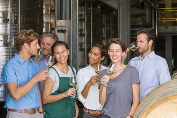 Winery employees tasting white wine in cellar