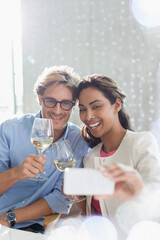 Couple with white wine taking selfie with camera phone