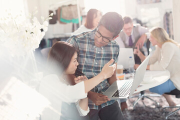 Fashion designers brainstorming with laptop in office