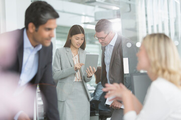 Fototapeta premium Business people sharing digital tablet in conference room