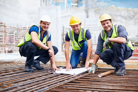 Portrait confident construction workers engineer reviewing blueprint at construction site