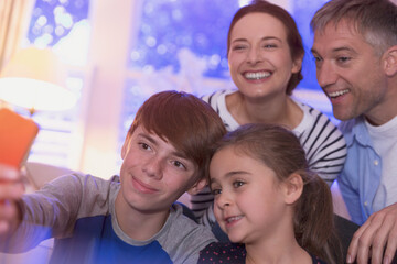 Smiling family taking selfie with camera phone