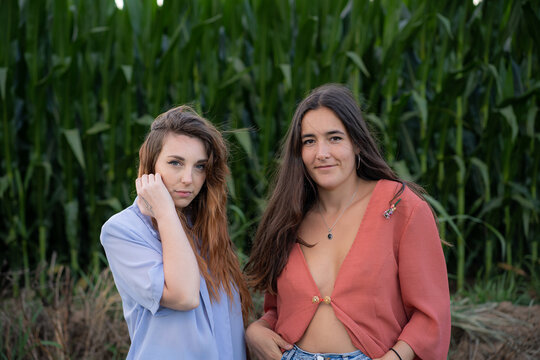 Dos chicas posan frente a un maizal