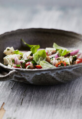 Salad with Olives, Cherry Tomatoes, Feta Cheese and fresh Basil on wooden Background. Healthy Snack Idea. Close up. 
