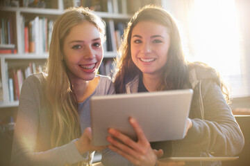 Portrait smiling teenage girls using digital tablet