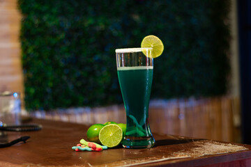 Michelada, Beer  cocktail of lemon, blue curacao and gummy worms at bar

