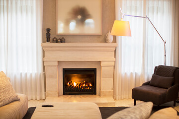 Illuminated floor lamp near marble fireplace