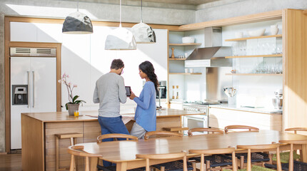 Couple using digital tablet in kitchen