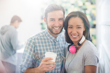 Portrait smiling creative business people with headphones and coffee