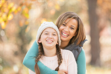 Portrait enthusiastic mother and daughter hugging outdoors