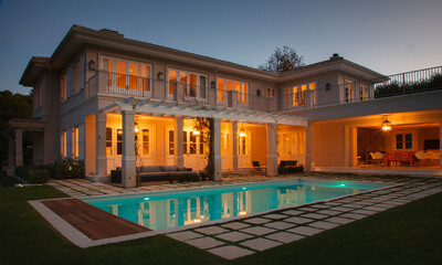 Illuminated luxury house with swimming pool at night