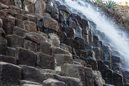 Waterfall and a hanging bridge at basaltic prism canyon at Hidalgo, Mexico