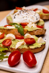Homemade avocado toast with tomatoes and eggs