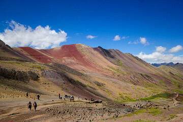 people climbing to reach vinicunca rainbow mountain