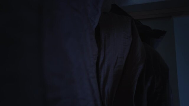 Night insomnia. Quarantine depression. Tired man with glitched face falling down on bed in blanket.