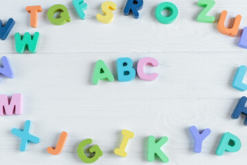 Close up Multicolored wooden letters with ABC on white wooden background. Set of toys for studying...
