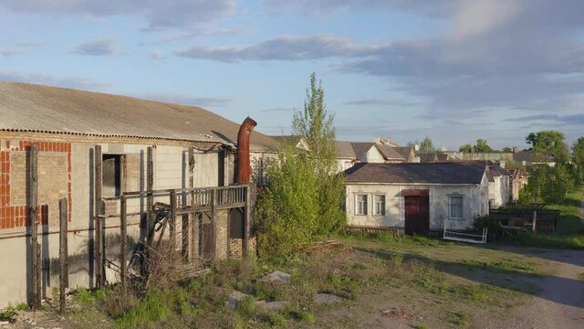 Abandoned town with a ghost (haunted) houses and a small factory on a deserted streets. Aerial low angle view