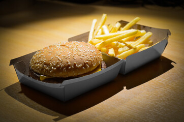 A fast-food restaurant hamburger (cheeseburger) with fries