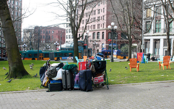 Luggage and belongings of homeless couple being used as protection from the cold wind in City Hall Park.