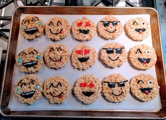 Tray of rice krispie puffed rice treats made to look like emoji faces