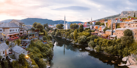Mostar, Bosnia and Herzegovina. Evening sun on the river Nerteva and the old town of Mostar, with Ottoman mosque