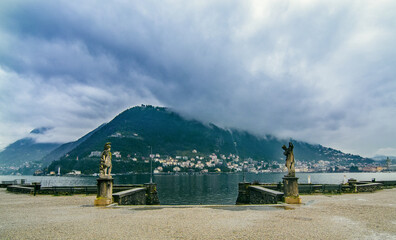 View of Lake Como with statues flanking the entrance to the shore