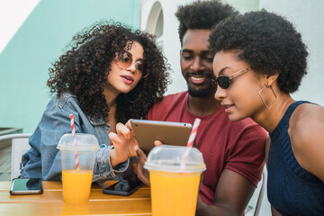 Three afro friends using digital tablet.