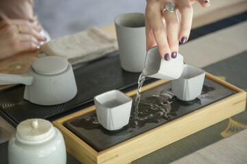 Chinese Tea Ceremony experience. Exquisite hot tea at traditional Chinese Tea Ceremony.  Caucasian woman participating in a traditional tea ceremony class. 