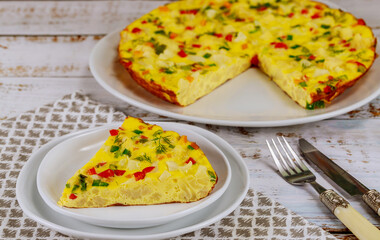 Homemade cauliflower omelette with fork and knife on white background.