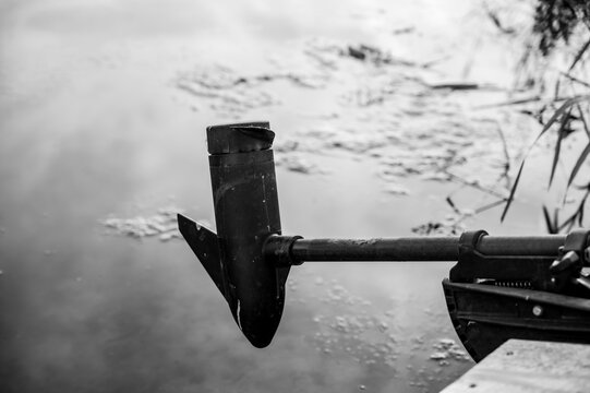 Boat Trolling Outboard Motor Extended Over Mossy Water