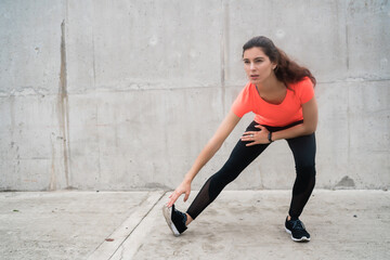 Fototapeta na wymiar Athletic woman stretching legs before exercise.