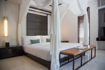 Simple contemporary bedroom with king size bed and mosquito net