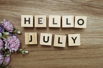 Hello July alphabet letters on wooden background