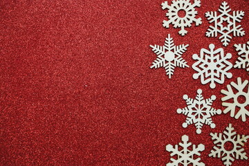 Fototapeta na wymiar wooden snowflake border frame on red glitter background