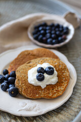 Oatmeal pancakes with yogurt and blueberries in white rustic tab