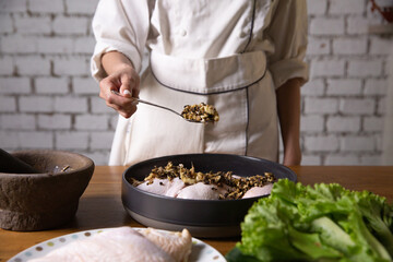 The chef cooks marinated chicken in his kitchen.