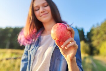 Young happy woman with red apple, girl biting an apple