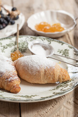 Croissants on a white plate with green ornament