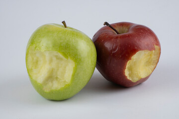 Bitten green and red apple on a white background