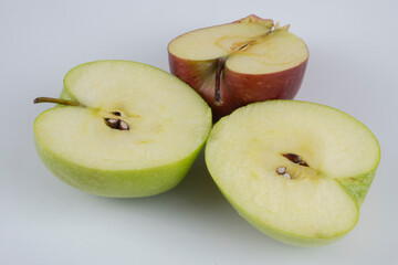 Red and green apple, half apple, bitten apple on a white background, seeds