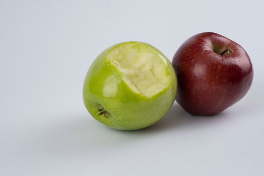 Bitten green and red apple on a white background