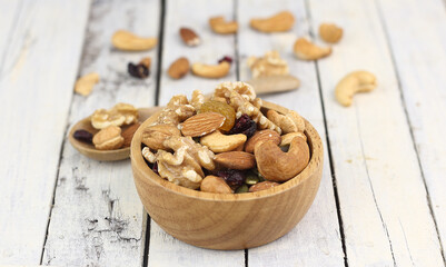 Bowl of mixed nuts on white wooden table