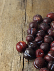 Obraz premium Organic fruits - group of plum lay on wooden table