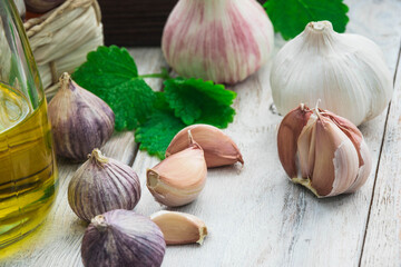 fresh raw garlic with salad and basil on wooden table