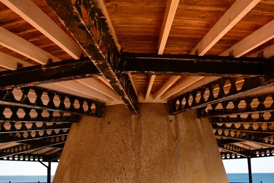 Underneath an old iron and wood beach shelter roof.