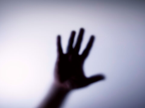 Blurred silhouette of hands and the inscription for stop .